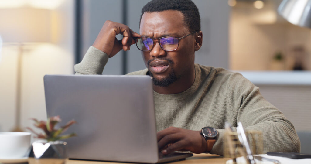 Frustrated man on a laptop in an office.