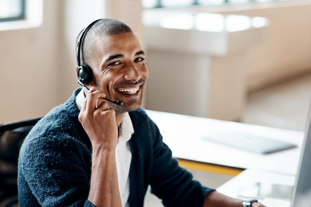 Young business man helping clients over the phone.