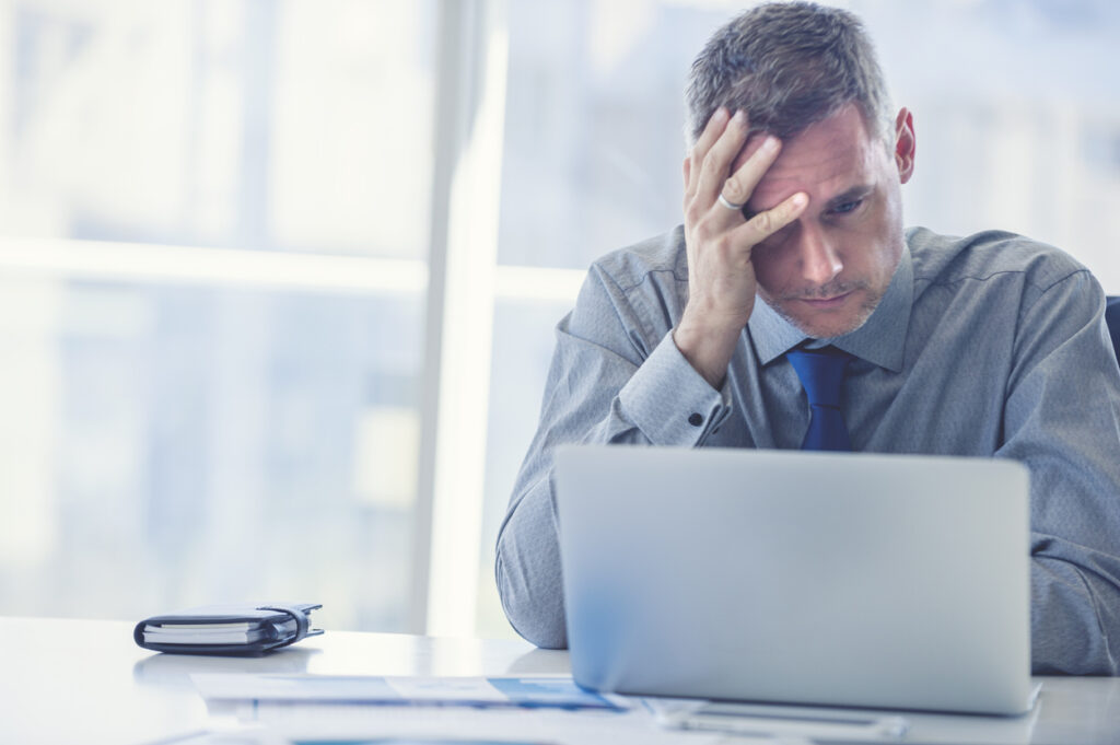 Frustrated business man working on a laptop.