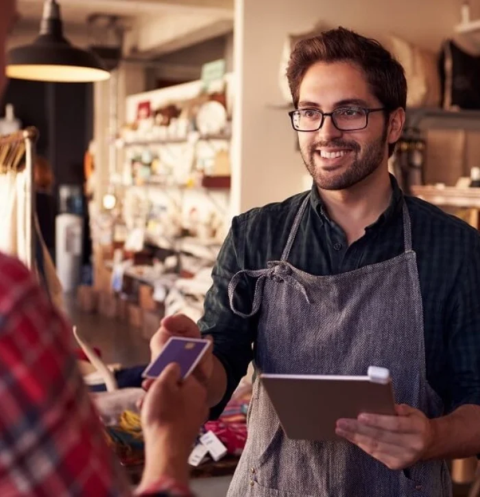 retail-payment Man working in retail takes card from customer for payment.